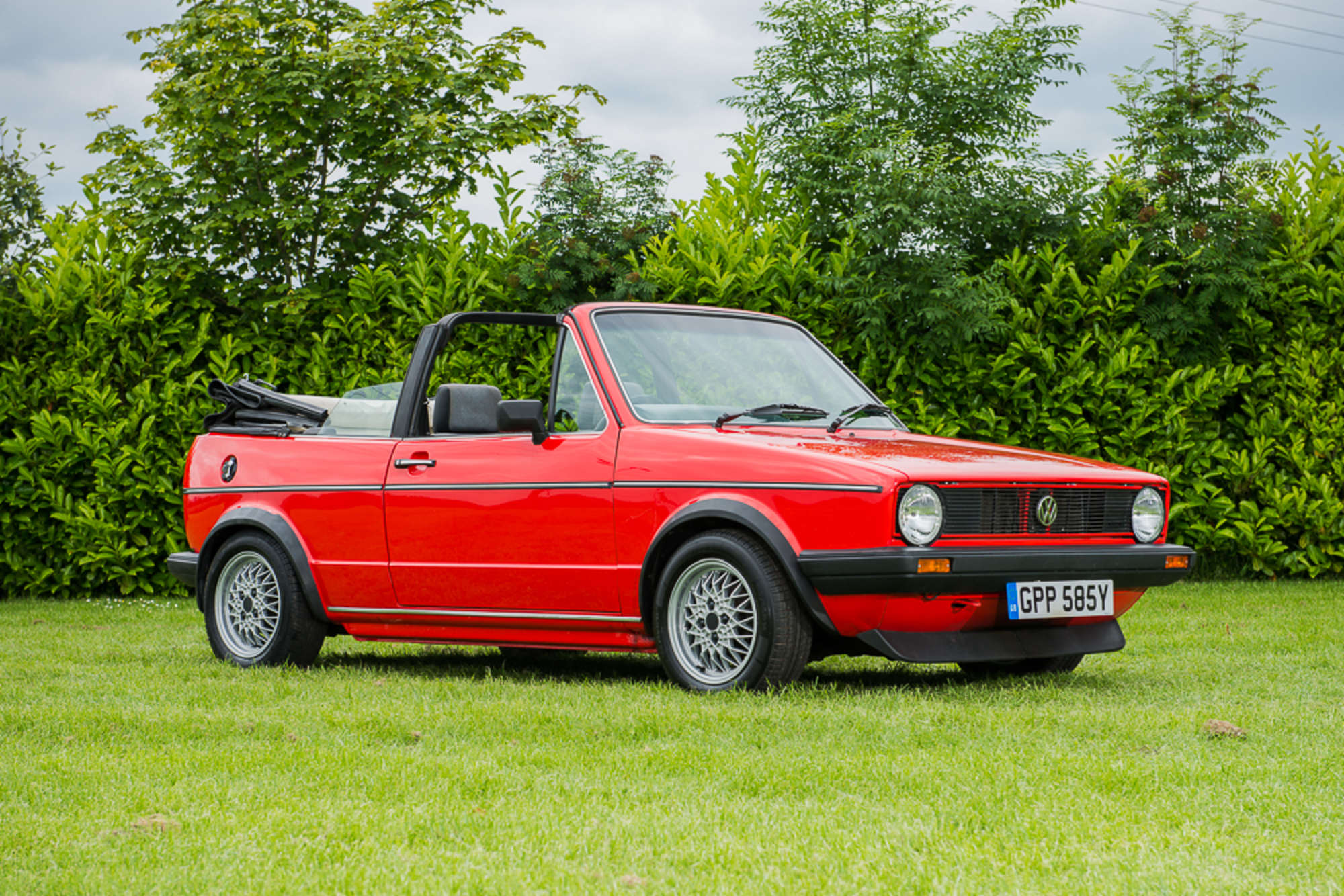 VW Golf I Cabriolet with the roof down, parked on a European street, clean lines, no visible seams at the hood