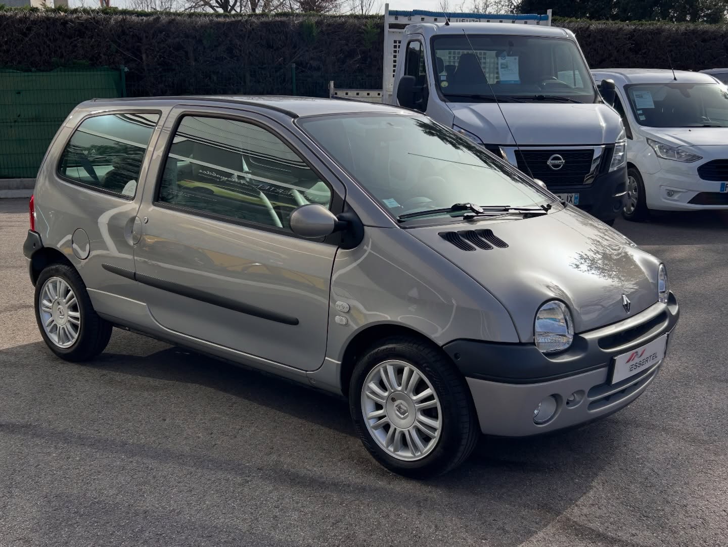 Renault Twingo I in white, the monobox body forms a single unbroken curve from windscreen to rear hatch, with no bonnet crease